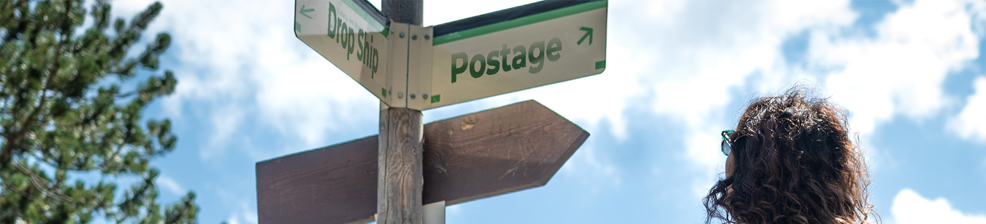 Faded trail sign pointing towards Drop Ship or Postage.